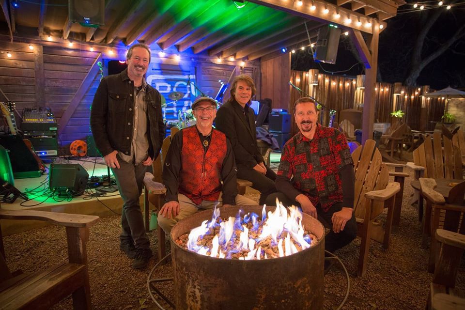 Hipsonic around an outdoor fire pit at night, under string lights