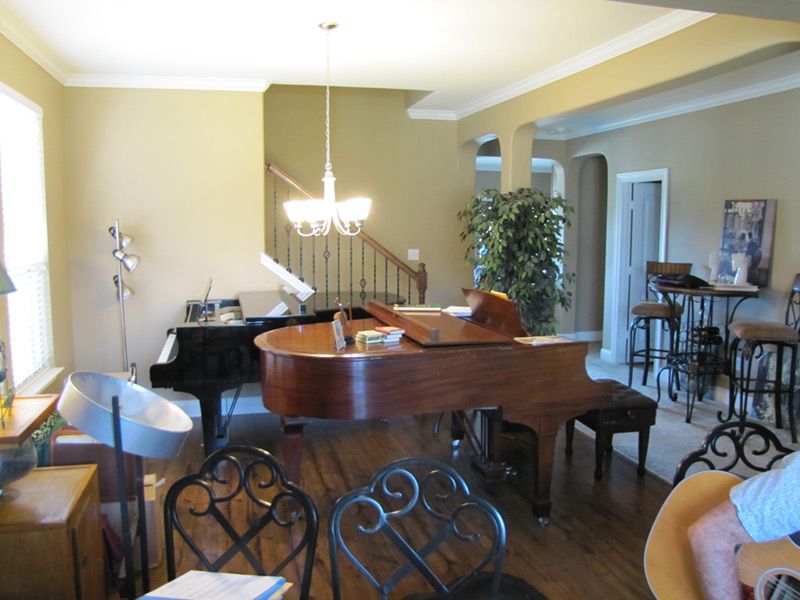 A grand piano in a bright front room